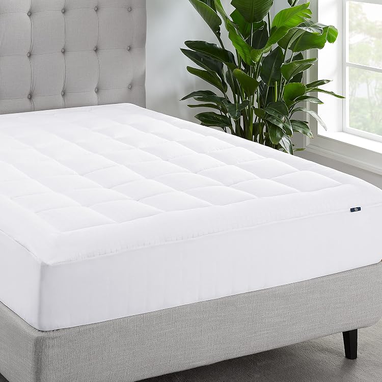White quilted mattress pad fitted on a bed