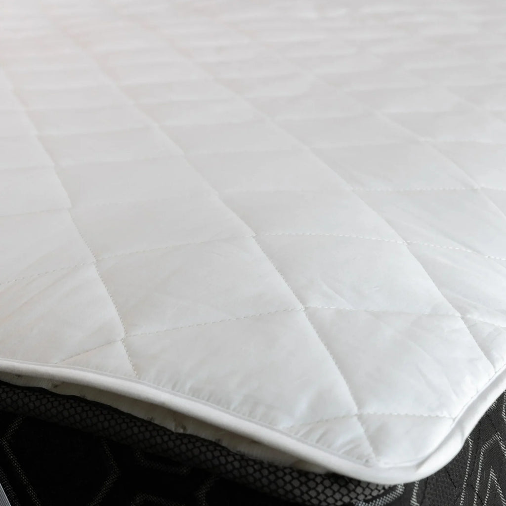 Macro detail of diamond-quilted mattress pad fabric